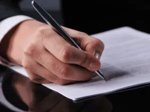 Des proches se tenant par les épaules et se soutenant mutuellement lors d'une cérémonie funéraire.