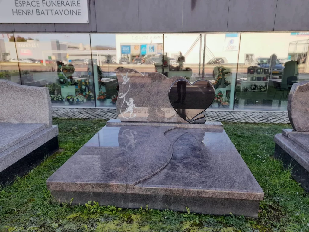 Monument funéraire double en granit rose avec stèle gravée d'un cœur.