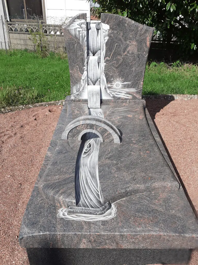 Sépulture gravée d'un paysage de cascade et pont sculpté dans le granit.