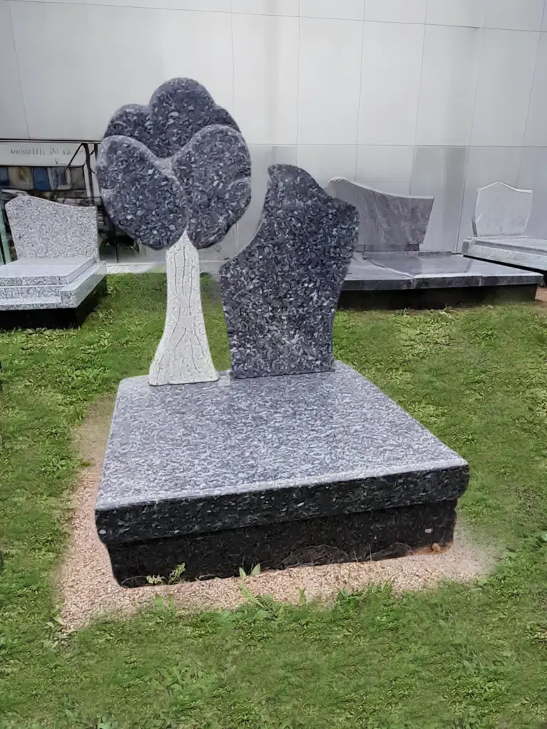 Monument cinéraire original en granit sculpté en forme d'arbre.